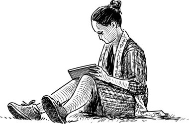 Bir öğrenci kız çim çimen üzerine bir kitap okur