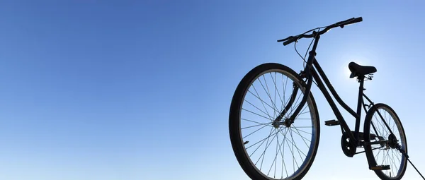 经典黑色自行车的背光轮廓 背景是蓝天 全景全景 文字空间 户外活动概念 — 图库照片