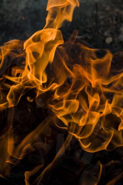 Yeryüzünün ve kömürlerin arka planında yanan parlak ateş.