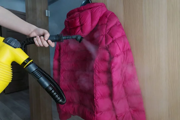 steam cleaning jacket with portable home steam generator. Disinfection from dust, viruses, allergen.Cleaning concept.