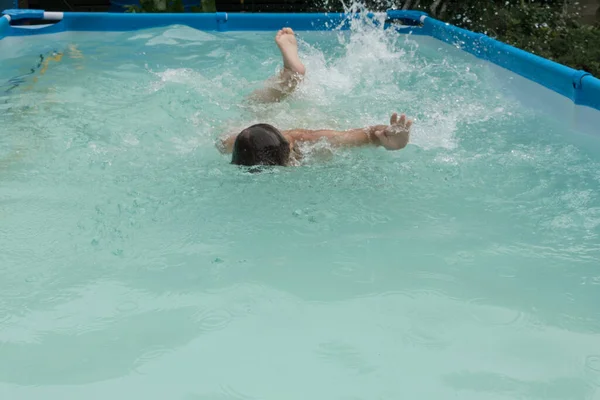 Menino Aprende Nadar Pequena Piscina Salpicos Água Mãos Pés Tenta — Fotografia de Stock