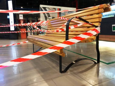 RUSSIA, ROSTOV-ON-DON - 18 Haziran 2020: Alışveriş merkezindeki bank insanların oturmasını engellemek için şeritli bant ile kaplıdır. Salgından korunma tedbirleri. 