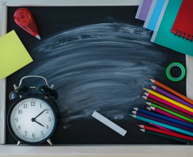 Tahtanın ortasında tebeşir izi, renkli okul tedarikçisi ve tahtanın köşelerinde siyah saatler olan karatahta görüntüsünü kapat. Okul konseptine dönelim..