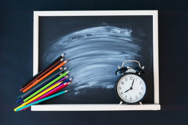 Tahtanın ortasında tebeşir izi, renkli kalemler ve tahtanın köşelerinde siyah saatler olan karatahta görüntüsünü kapat. Okul konseptine dönelim..