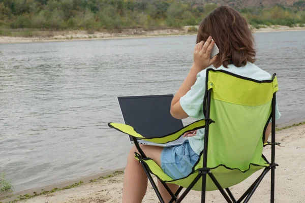 Junge Frau Sitzt Ufer Des Flusses Mit Laptop Auf Knien — Stockfoto