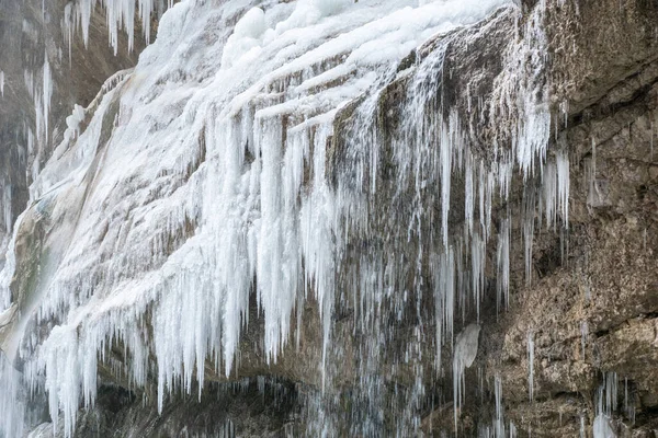 big white icicles of beautiful frozen waterfall. Beautiful winter landscape. Change of climate.