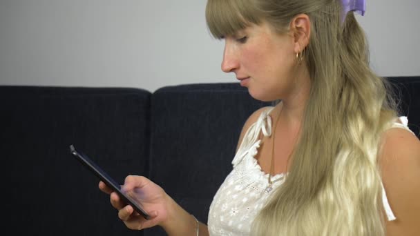 Yakın Plan Bir Kız Evinde Kanepede Telefonla Yazıyı Okurken Şaşırdı — Stok video