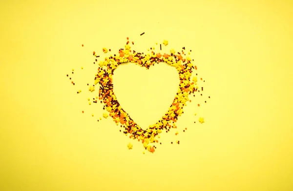 Nonpareil a forma di cuore su sfondo giallo — Foto Stock