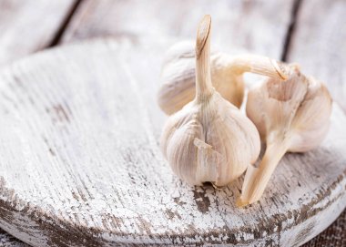 Hafif ahşap arka planda taze sarımsak.