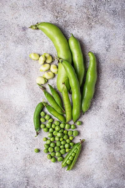 Färska gröna ärtor och bönor på ljus bakgrund — Stockfoto