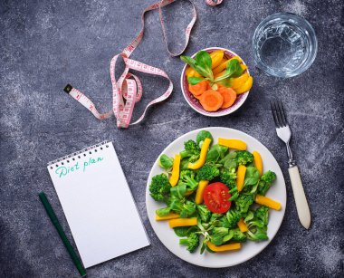 Sağlıklı salata, temiz su ve ölçüm bandı. Ağırlık kaybı kavramı