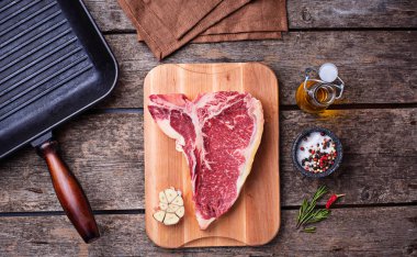 Pan çiğ T-bone biftek ve demir ızgara