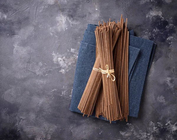 Fideos soba japoneses crudos sin cocer en bacground gris — Foto de Stock