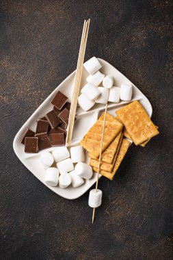 Marshmallows toasting ve ev yapımı şekerleme yemek için malzemeler