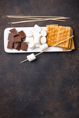 Marshmallows toasting ve ev yapımı şekerleme yemek için malzemeler