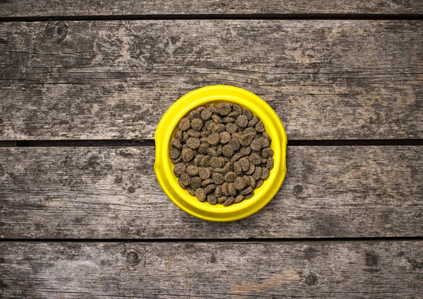 Cuenco de comida seca para perros en suelo de madera — Foto de Stock