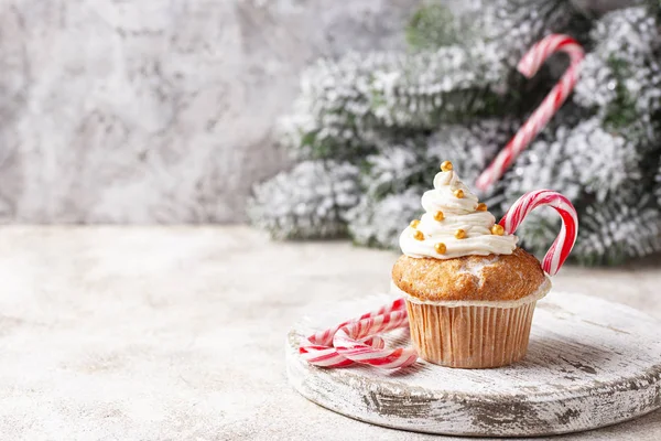 クリームとキャンディー杖とクリスマスお祝いカップケーキ光の背景 — ストック写真
