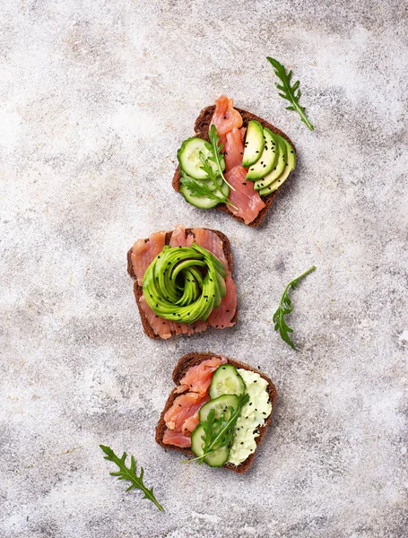 Healthy toasts with salmon and avocado rose — Stock Photo, Image