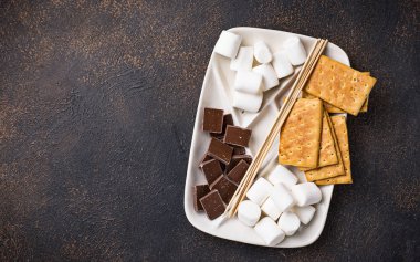 Marshmallows toasting ve ev yapımı şekerleme yemek için malzemeler