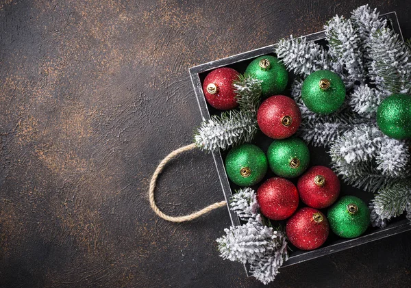 Red and green Christmas tree balls in wooden box — Stock Photo, Image