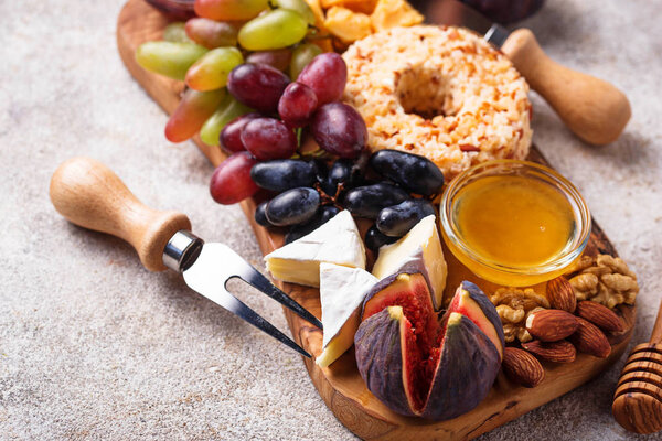 Appetizer for wine, cheese plate with grapes and figs. Food background