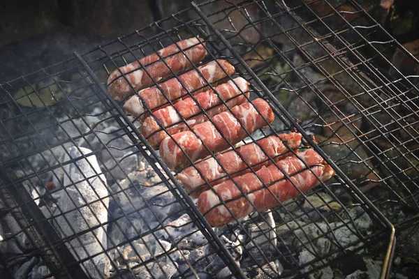 Grilling sausages wrapped becon on  grill — Stock Photo, Image
