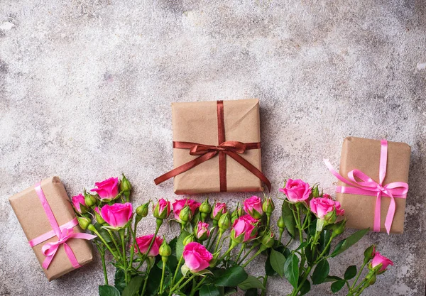Růžové růže a dárkové krabice s pásky — Stock fotografie