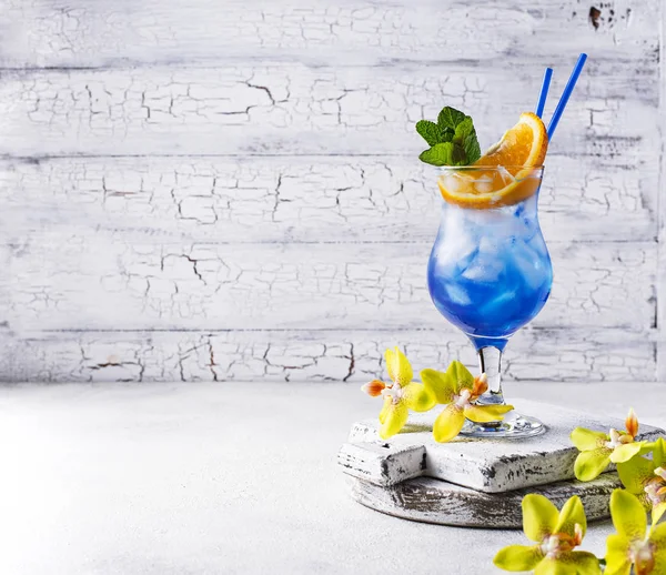 Modrý koktejlový nápoj s ledem a oranžovým — Stock fotografie