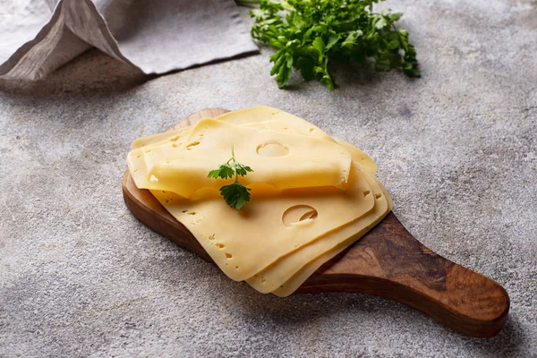 Sliced cheese on cutting board — Stock Photo, Image