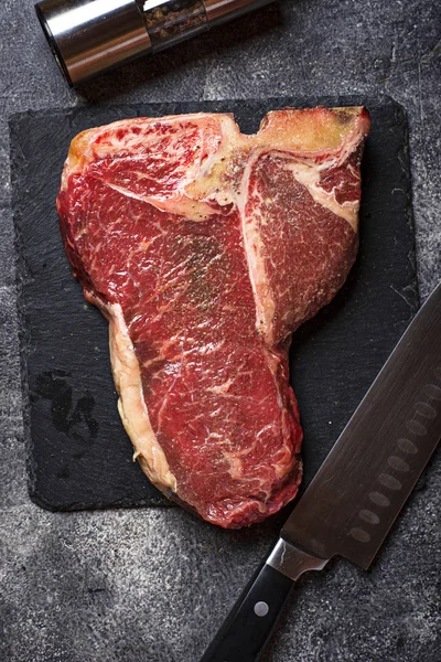Bifteck T-bone cru sur planche d'ardoise — Photo