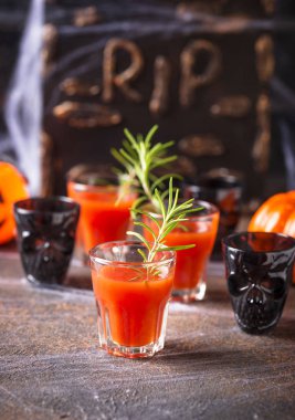 Cadılar bayramı Bloody Mary kokteyli içer.