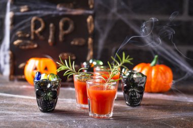 Cadılar bayramı Bloody Mary kokteyli içer.