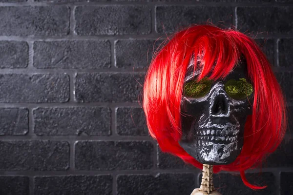 Human skull with red wig