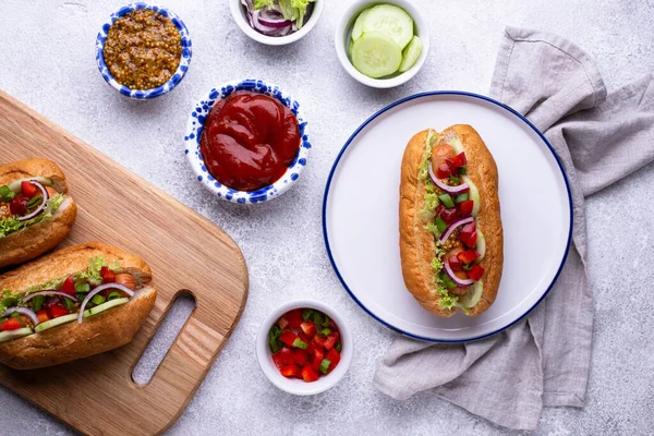 Хот-доги с колбасой, соусами и овощами — стоковое фото