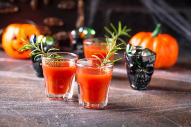 Cadılar bayramı Bloody Mary kokteyli içer.