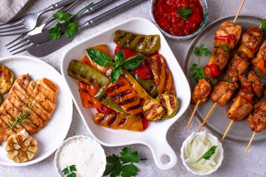 Çeşitli yaz ızgara bbq çeşitleri. Shashlik, ızgara sosis, sebze ve sos.
