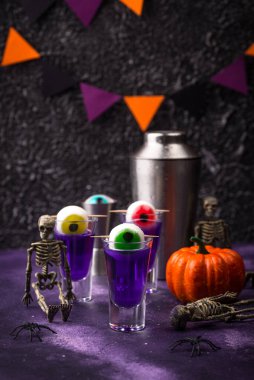 Cadılar Bayramı içkisi. Gözlerle süslenmiş mor shot kokteyli..