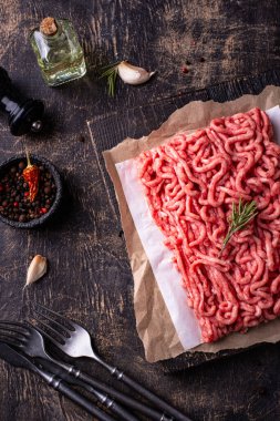 Koyu arkaplanda baharatlı çiğ et.