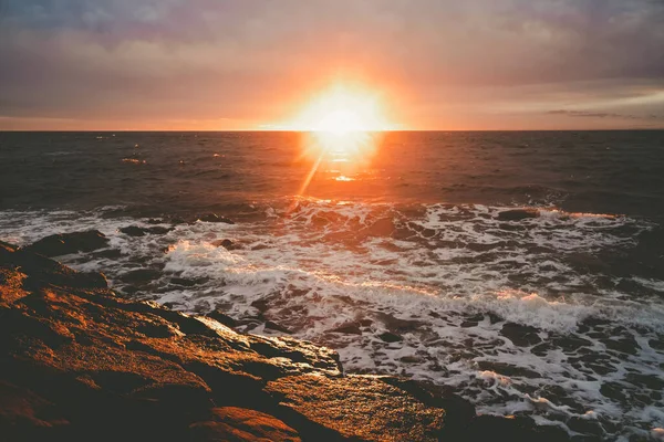 Retro analog sunset over sea with sun flare