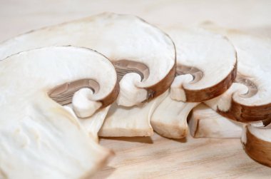 Ahşap Doğrama tahtası üzerinde taze champignon mantar dilimlenmiş. Sığ derinlik-in tarla, portre