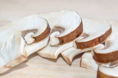 Ahşap Doğrama tahtası üzerinde taze champignon mantar dilimlenmiş. Sığ derinlik-in tarla, portre