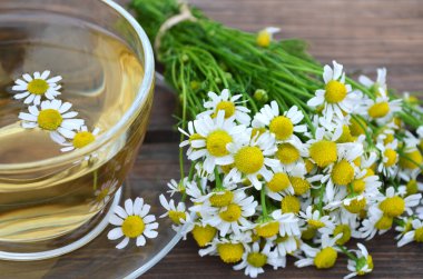 Bir buket papatya çayı ve bir fincan sıcak bitki çayı.