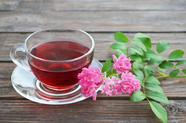 Tasse frisch zubereiteten heißen Tee und rosa Rosen — Stockfoto