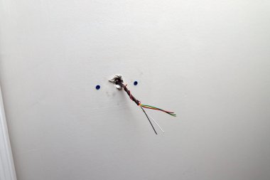 Kurulum sırasında duvardan çıkan, bir HVAC ünitesi ile kullanılan termostat için kontrol kablosunun yakın plan görüntüsü