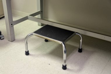 Old vintage step stool in medical exam office clipart