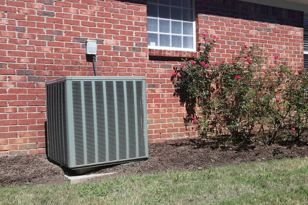 Air conditioner unit. clean modern, at a home with rose bushes