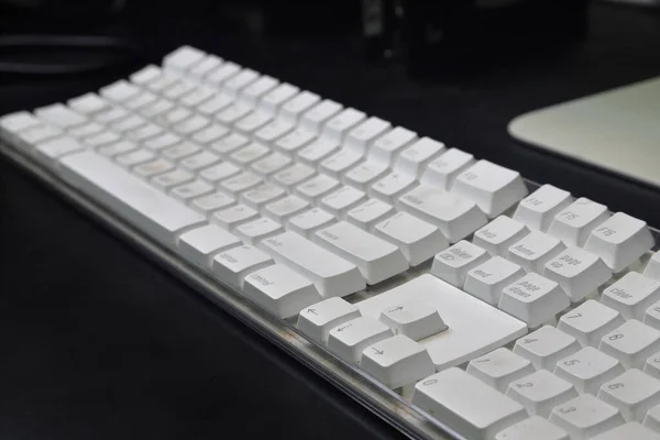データ入力に使用される黒い机の上の白いコンピュータのキーボード — ストック写真