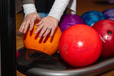 Bowling toplarının önünde ellerini kurutan atıcı.