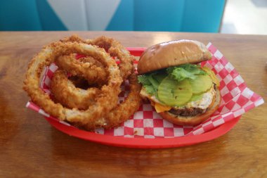 Lezzetli ızgara çizburger ve kızarmış soğan halkaları.