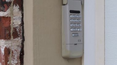 Bir evin garaj girişinde kullanılan tuş takımının gizli kodunu elle girmek - güvenlik şifresi -